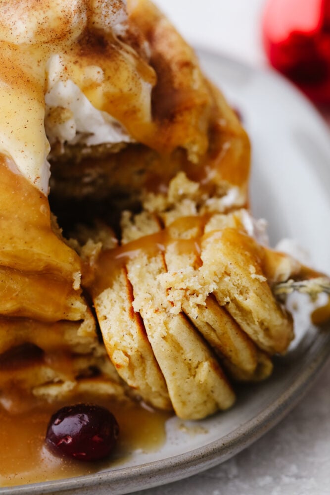 Eggnog pancakes being sliced with a fork. 