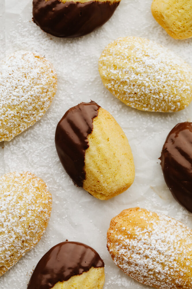 Powdered sugar and chocolate dipped madeleines. 