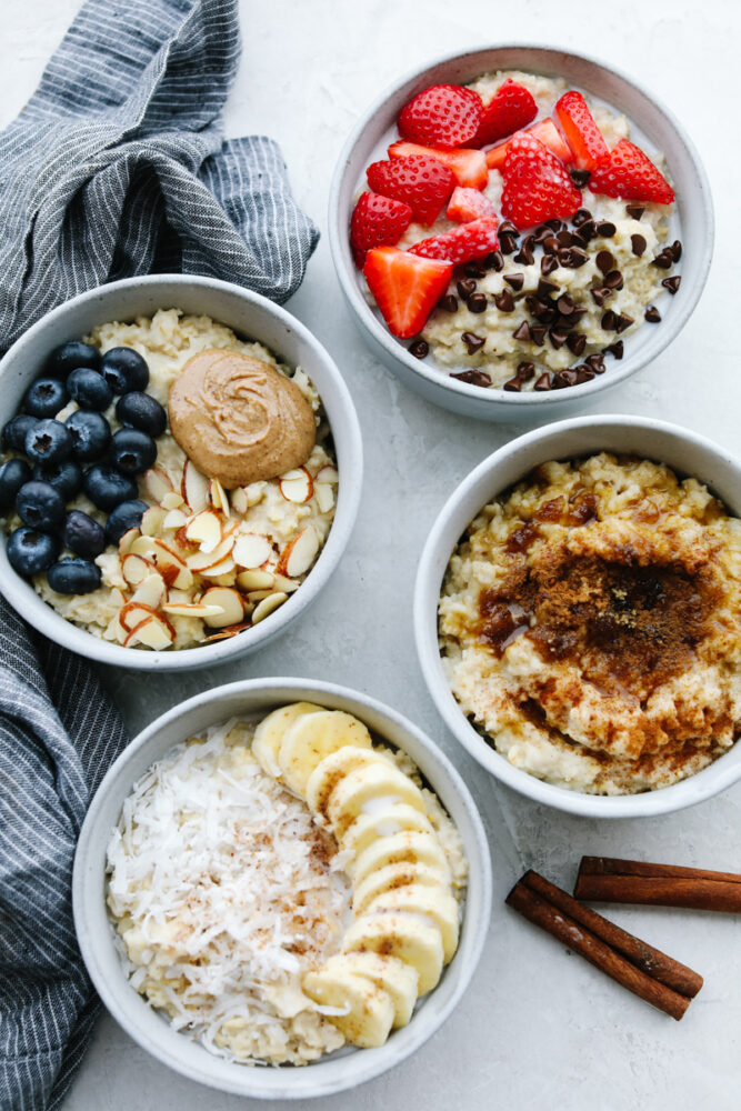 4 bowls of homemade oatmeal with various toppings.