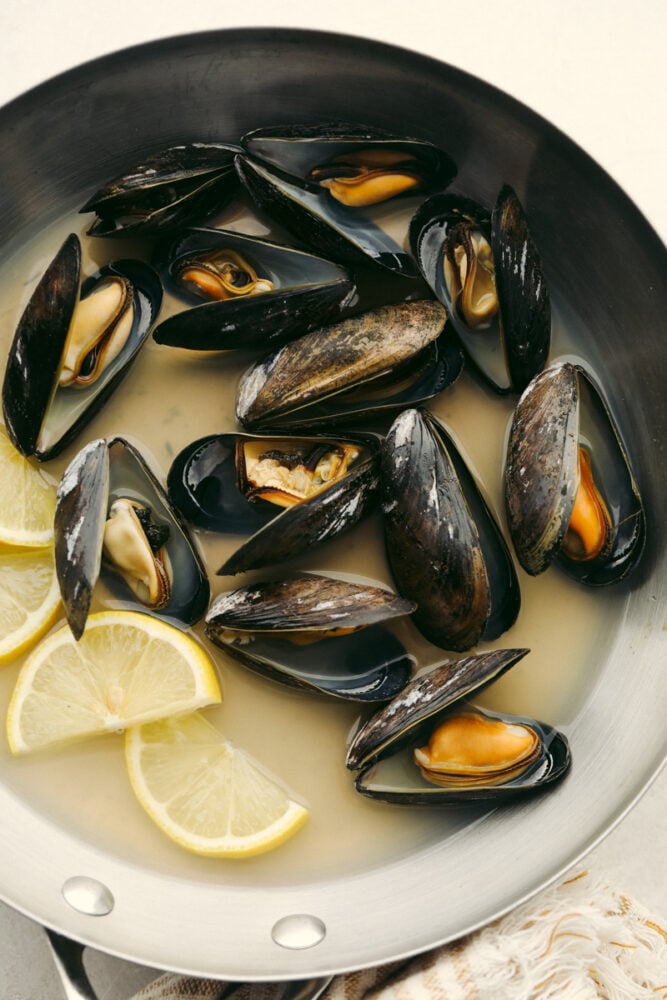 Mussels in a pot that are cooked and ready to eat. 