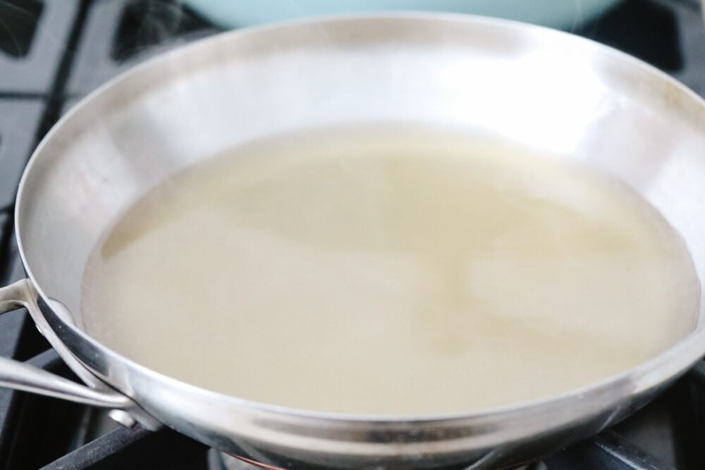 A pan filled with white wine and chicken broth. 