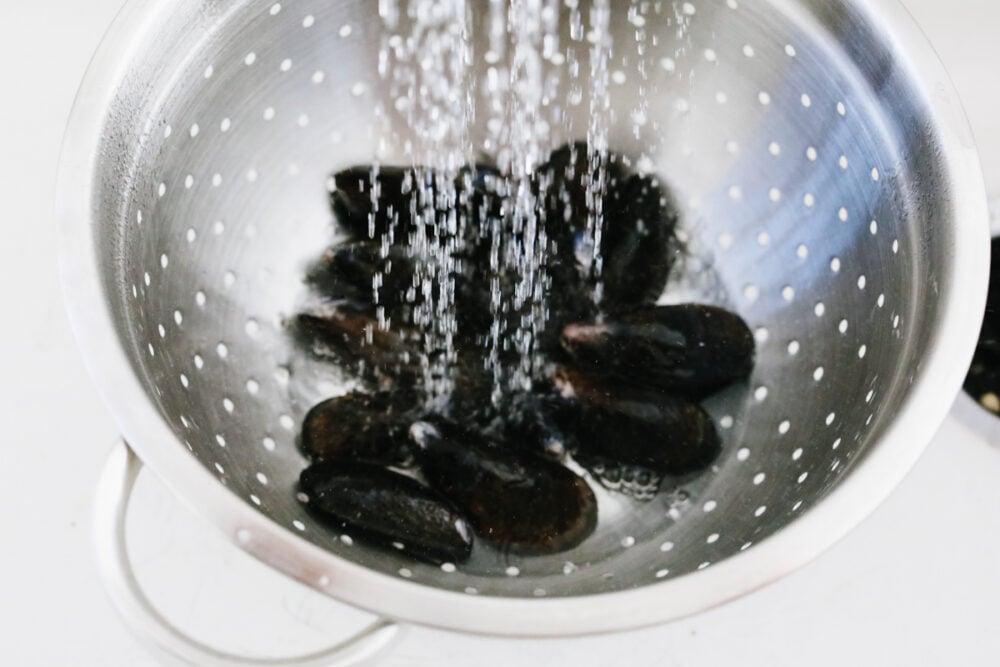 Mussels being rinsed with water. 