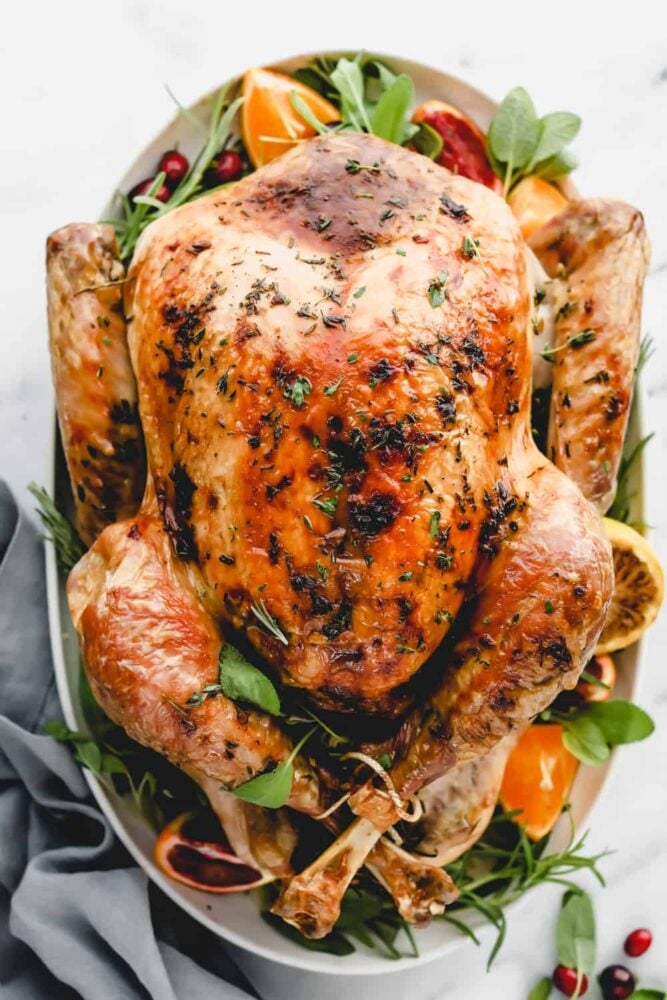 A finished oven baked herb turkey in a serving dish.