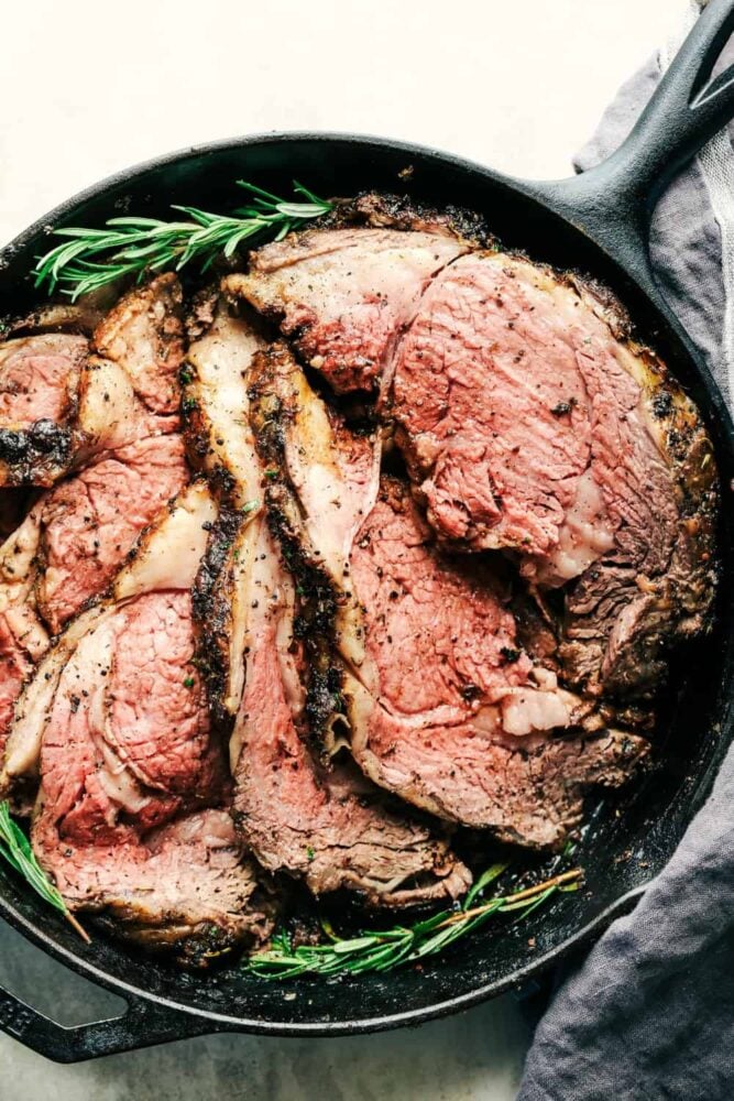 Prime rib that is in a pan, sliced and ready to serve. 