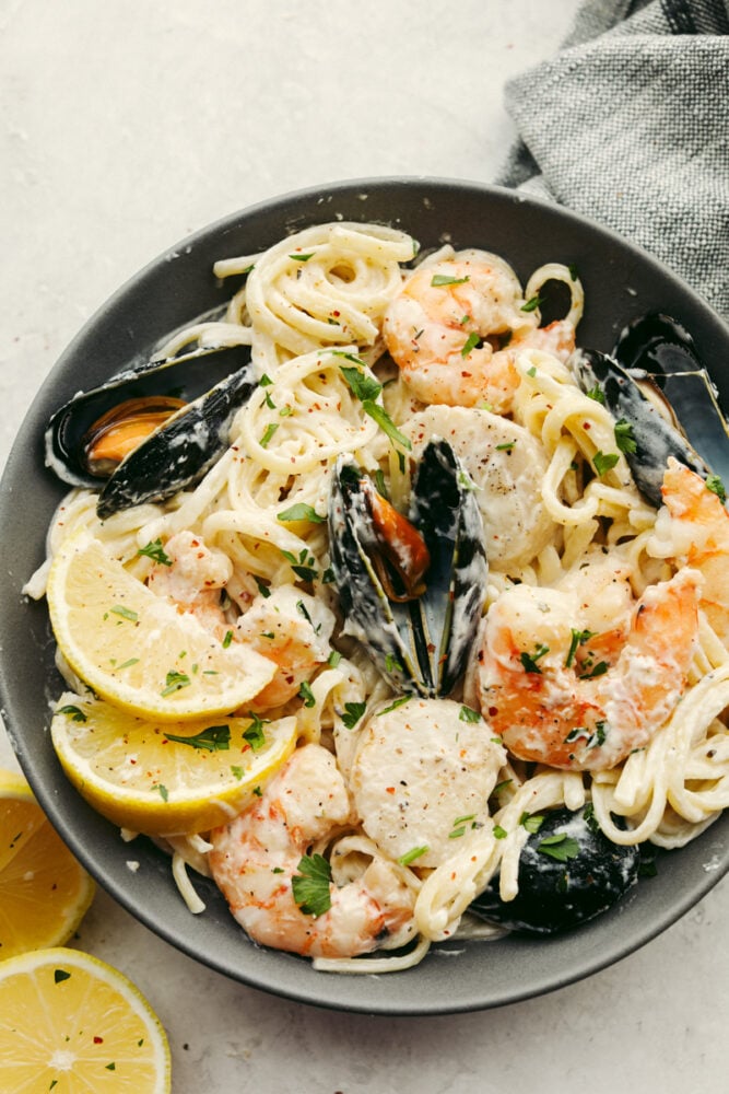 A pan filled with pasta and shellfish, ready to eat. 