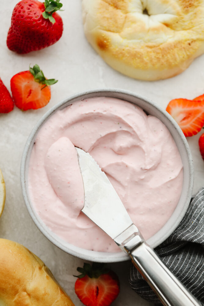Strawberry cream cheese in a bowl with a butter knife. 