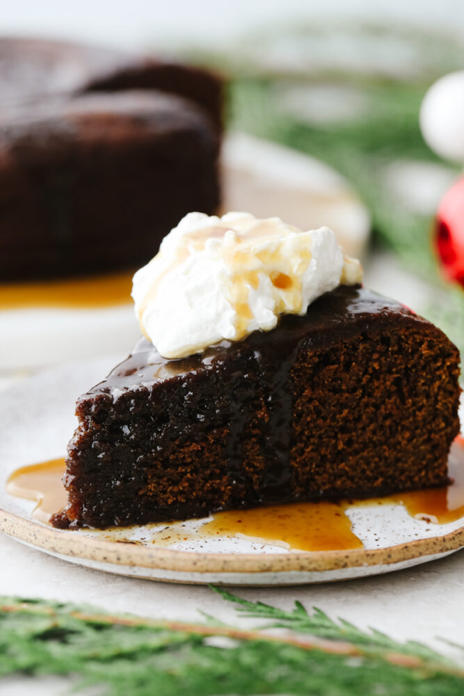 A slice of gingerbread cake with a dollop of whipped cream. 