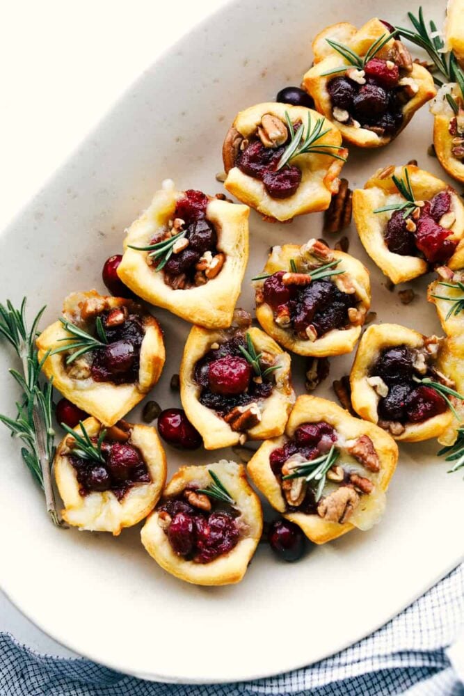 Cranberry pecan brie bites on a serving platter. 