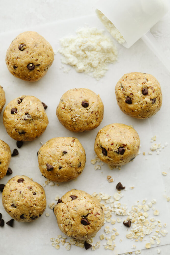 Chocolate chip protein balls laid out on parchment paper.
