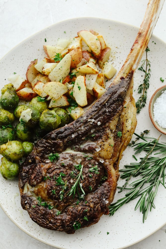 A plate with steak, potatoes and brussel sprouts. 