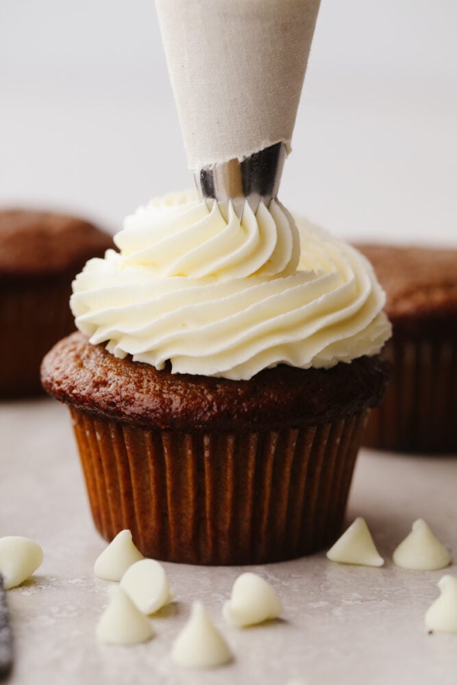 A chocolate cupcake piped with white chocolate buttercream.