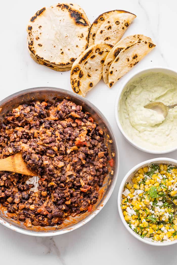 the fillings for black bean tacos on a marble countertop