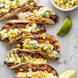 black bean tacos with lime wedges and corn salsa