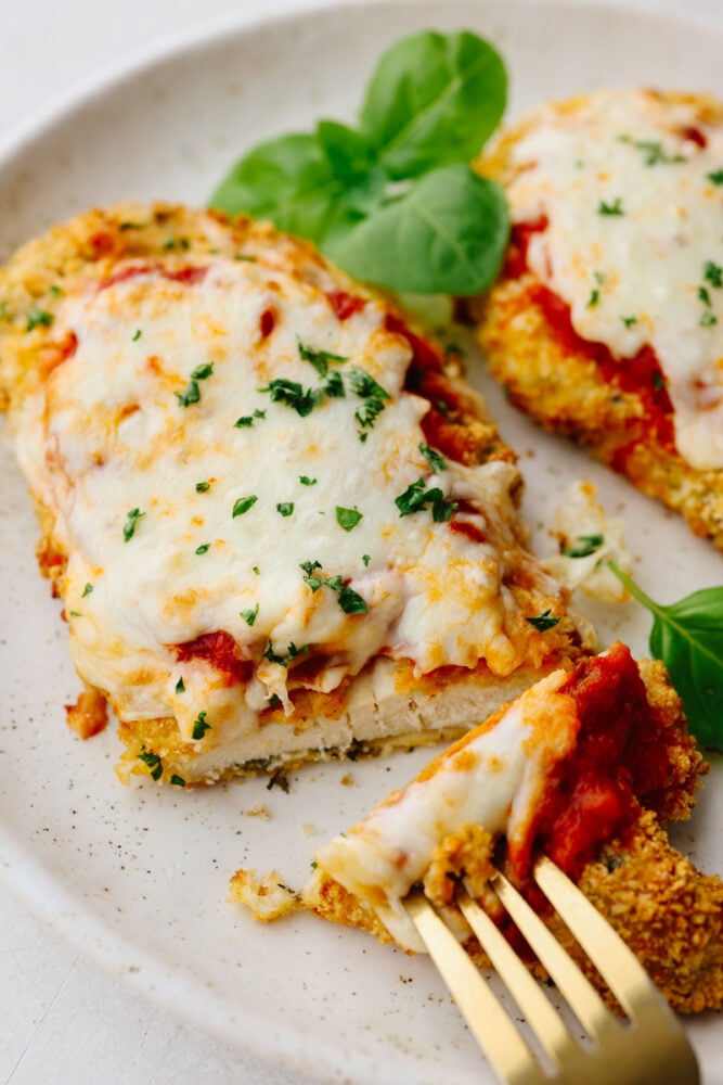 Closeup of a bite of chicken parmesan.