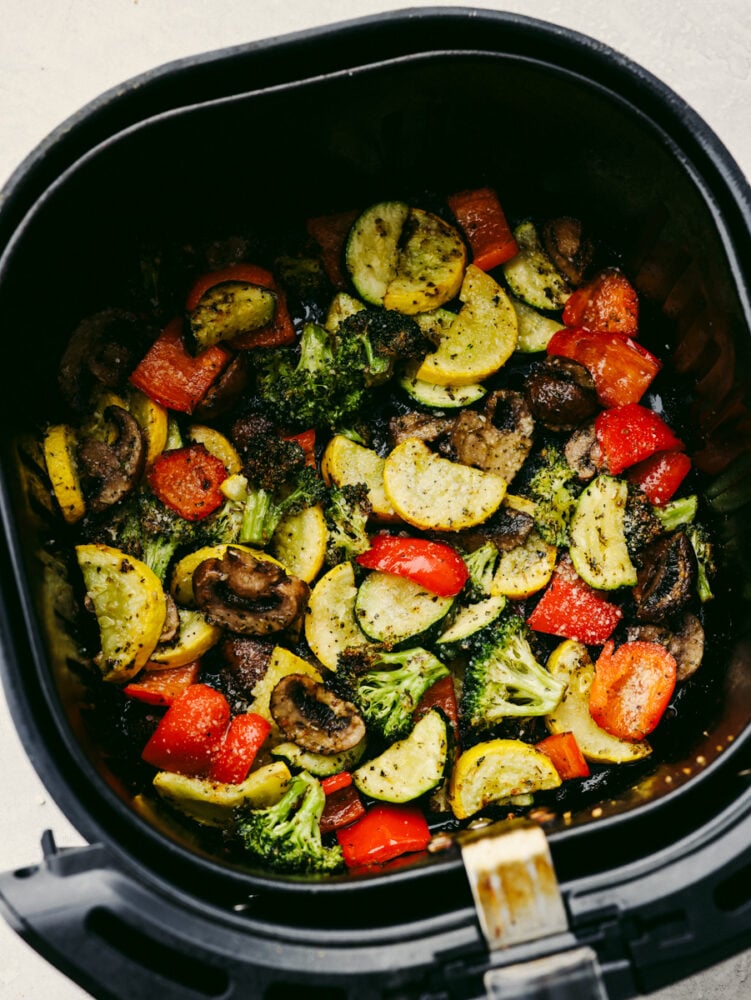 Vegetables being cooked in an air fryer. 