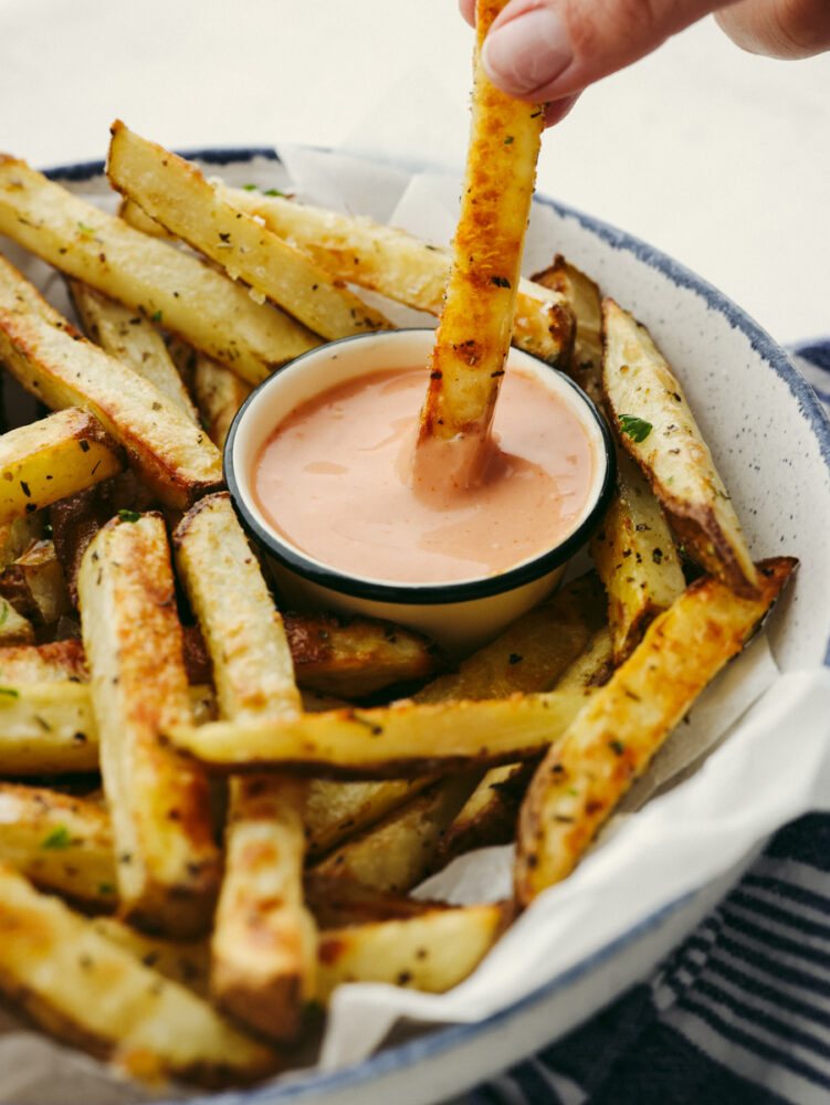 Dipping a fry into fry sauce.