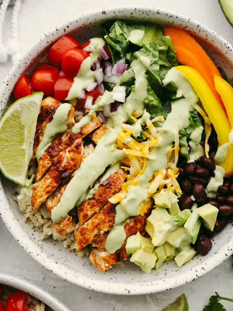 Closeup of a burrito bowl topped with cilantro ranch dressing.