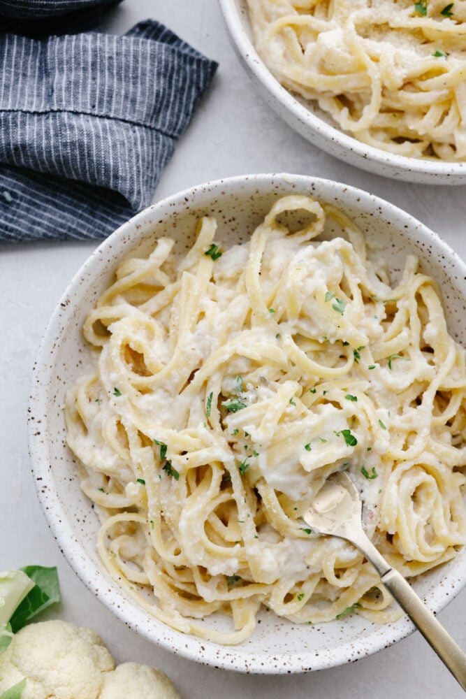 Bowls of cauliflower sauce on fettuccine. 