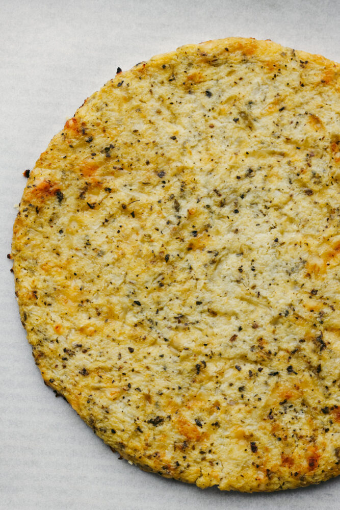 A cauliflower pizza crust all cooked and ready to go. 
