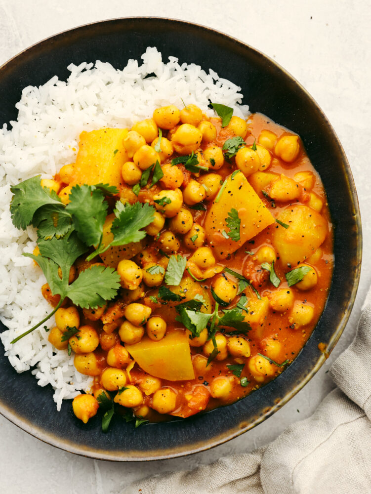 Chickpea curry served over rice in a skillet.