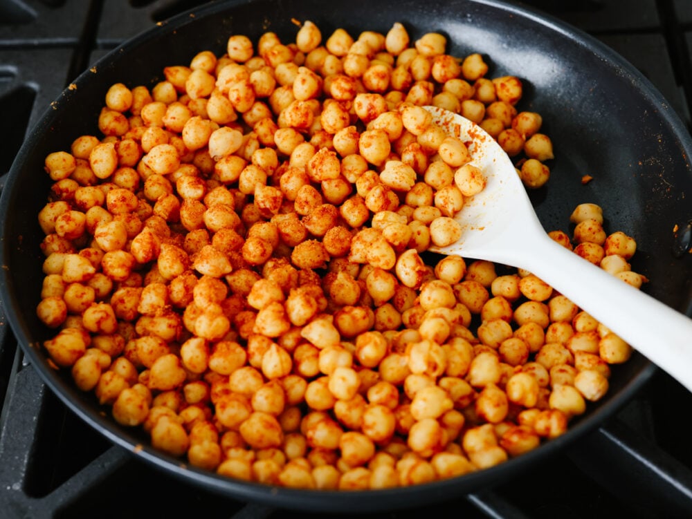 Seasoned chickpeas cooking in a skillet.