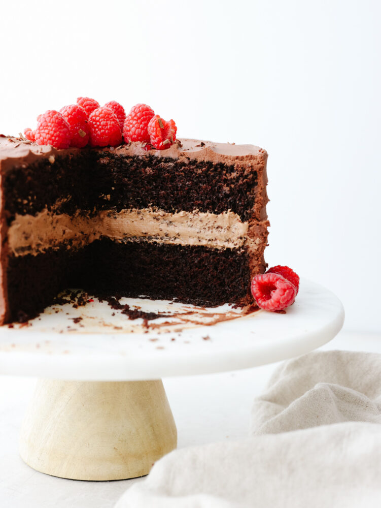 A sliced chocolate mousse cake on a cake pedestal. 