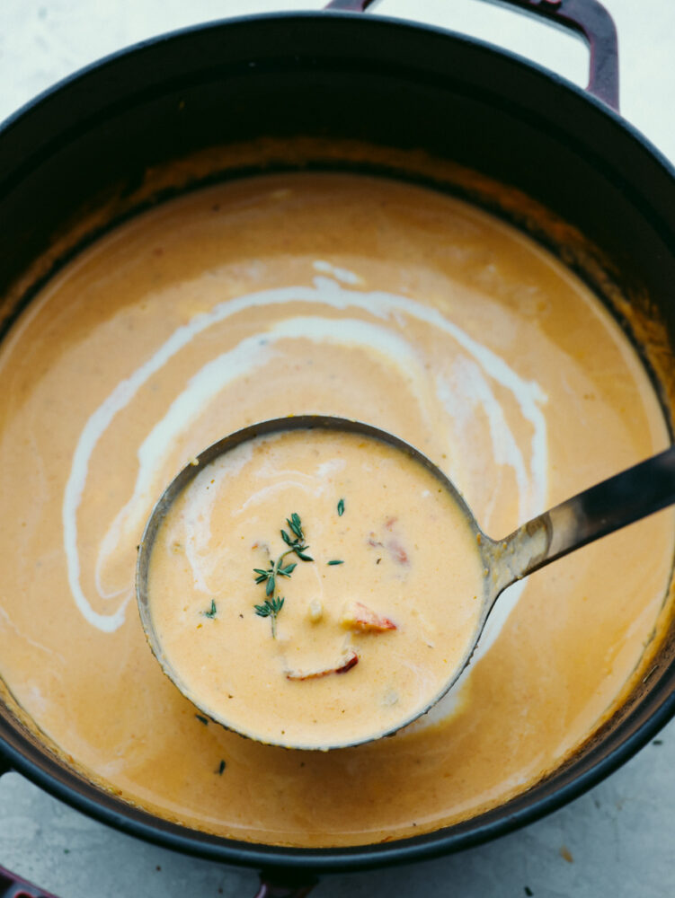 A pot of lobster bisque with a ladle. 