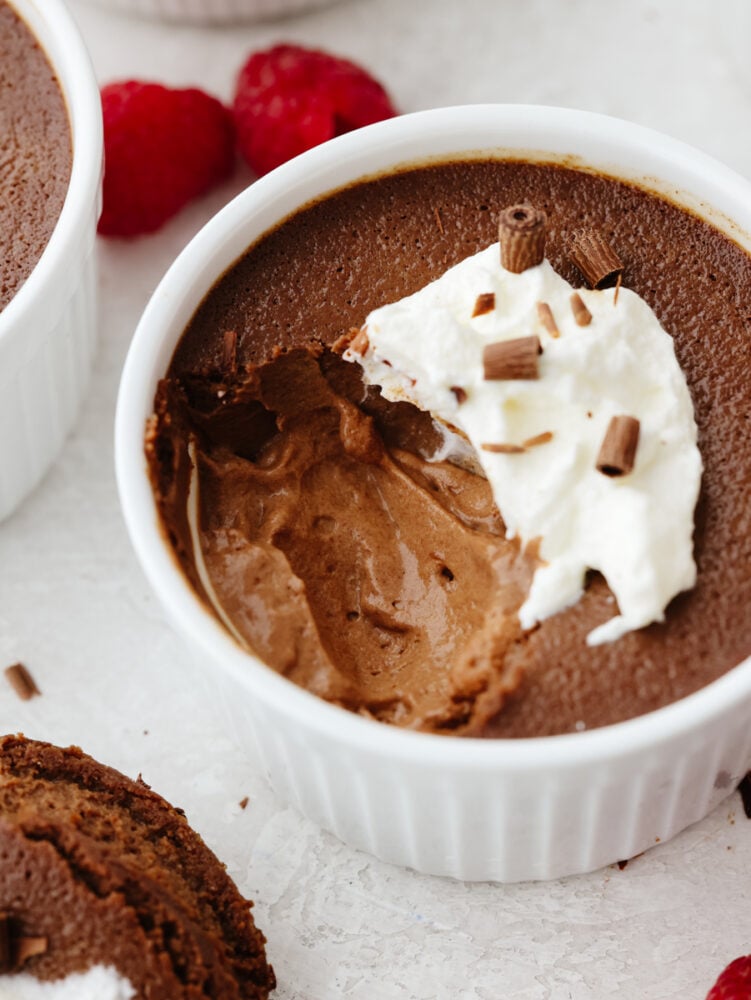 Pot de creme in a ramekin with a scoop taken out. 