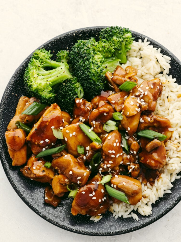 A bowl of rice topped with broccoli and teriyaki chicken. 