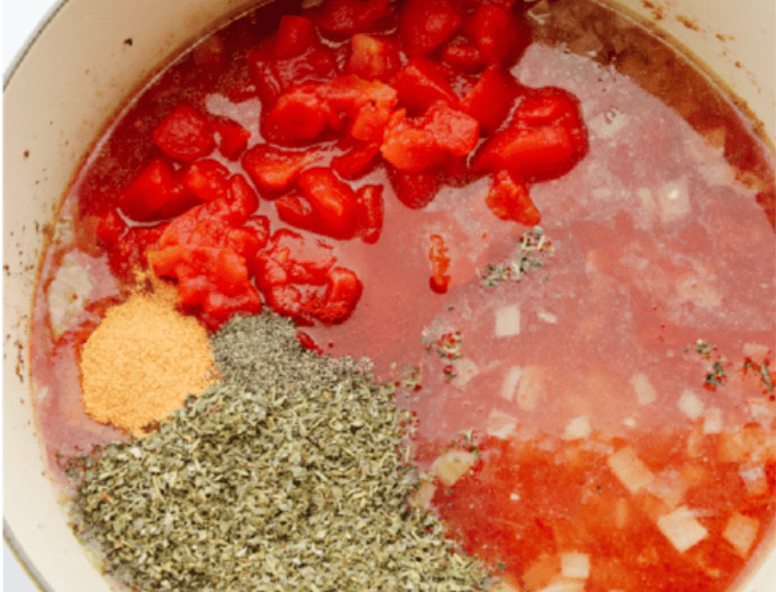 American Goulash is my kind of comfort food! It's rich, savory, and full of that cozy, tomato-y goodness. It’s hearty, easy to make, and one bite will have you hooked just like my family is! Tomatoes, water, and seasonings added to the pot with the onions.