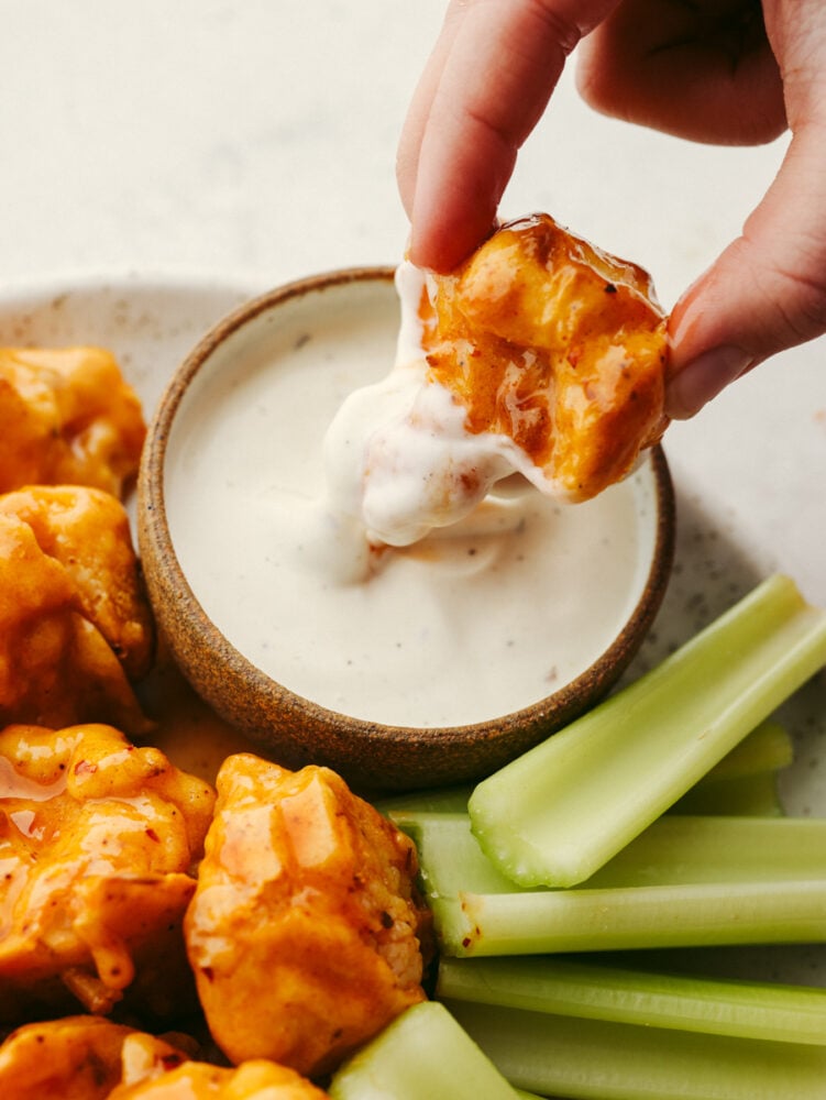 Dipping a cauliflower wing in ranch.