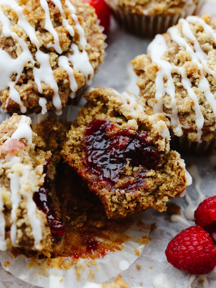 A coffee cake muffin cut open to show the raspberry preserve filling. 