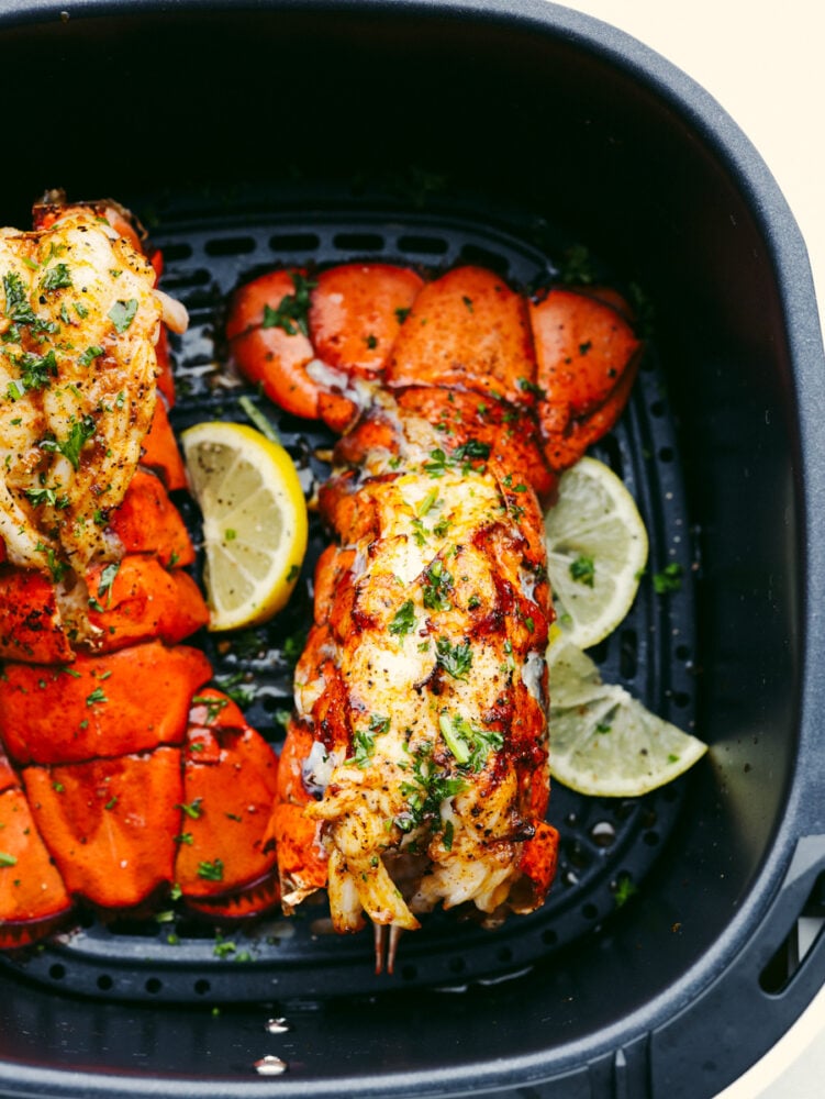 Lobster tails in the air fryer with lemon slices. 