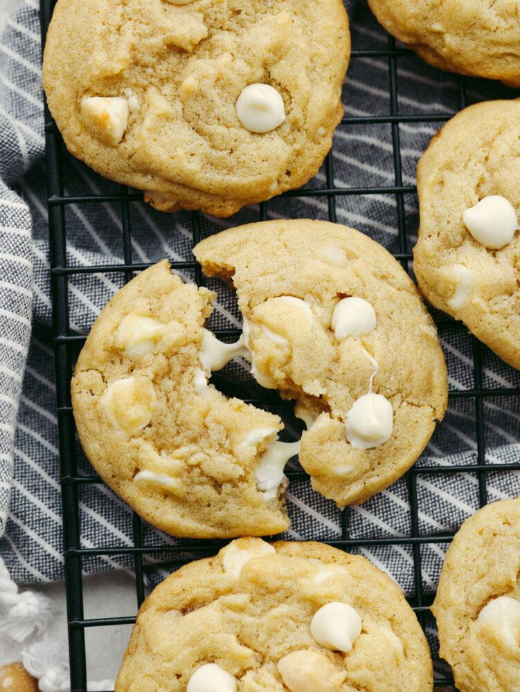 A cookie broken in half with melted white chocolate chips. 