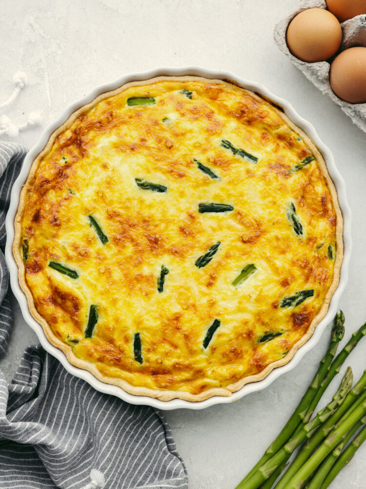 The top view of a fully cooked asparagus quiche, ready to cut and serve. 