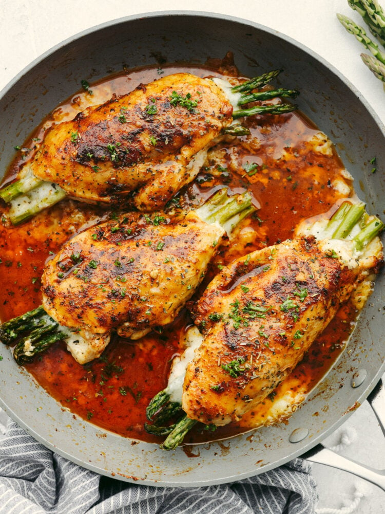 A pan nwith 3 asparagus stuffed chicken breasts. 