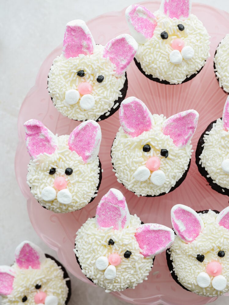 Bunny cupcakes on a pink cake platter. 