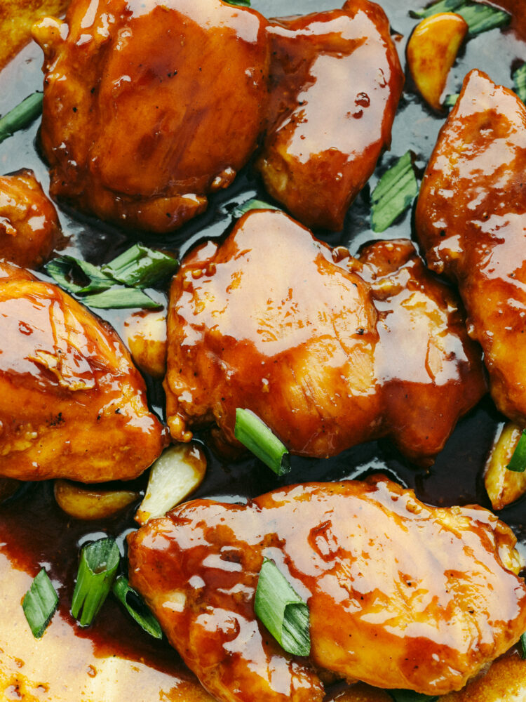 Closeup of chicken covered in caramelized Asian sauce.