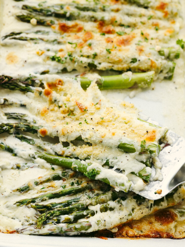 Baked asparagus being served with a spatula. 