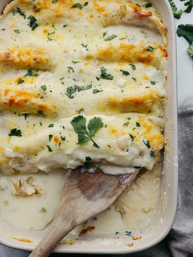 A baking pan filled with cooked white chicken enchiladas. 