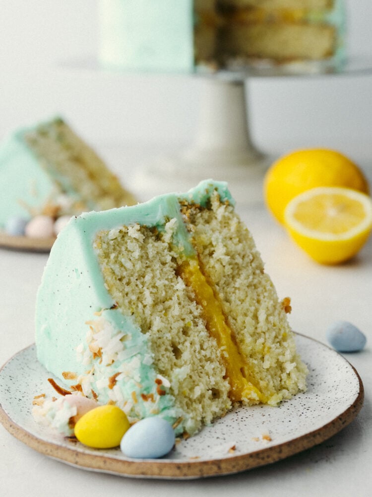 A slice of Easter cake on a plate with chocolate eggs next to it. 