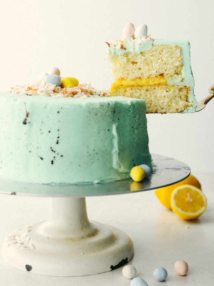 A robin egg blue cake with a slice being lifted out. 