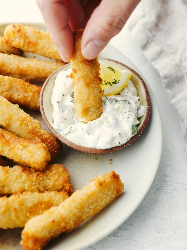 Dipping a fish stick in tartar sauce.