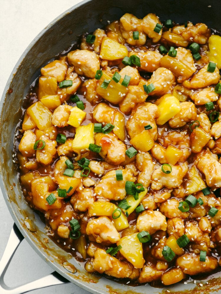Pineapple chicken simmering in a pan.