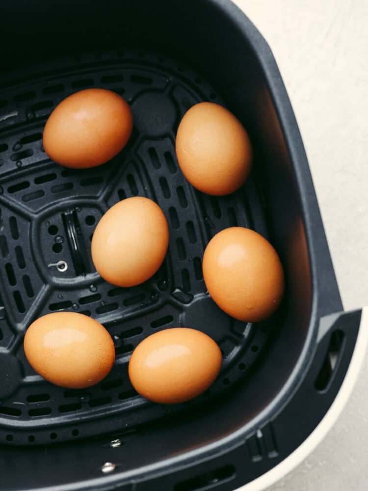 A close up of 5 brown eggs in the air fryer. 