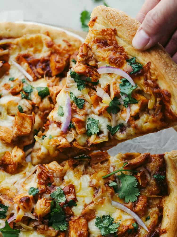 A slice of pizza being taken off of the pan. 