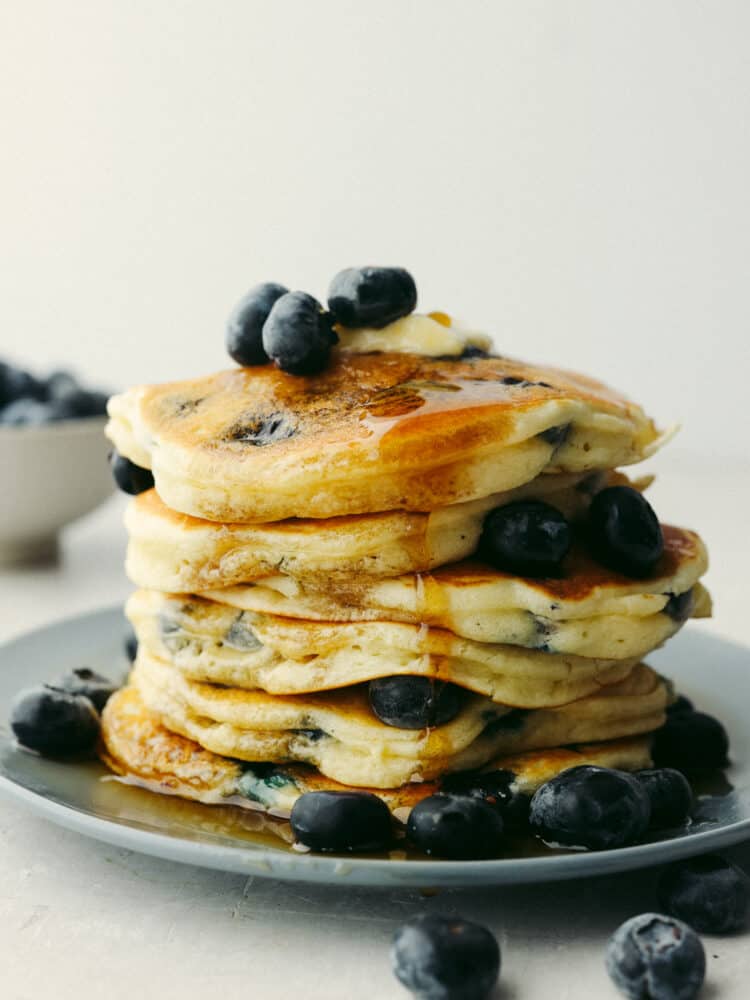 A stack of blueberry pancakes with fresh blueberries on top. 