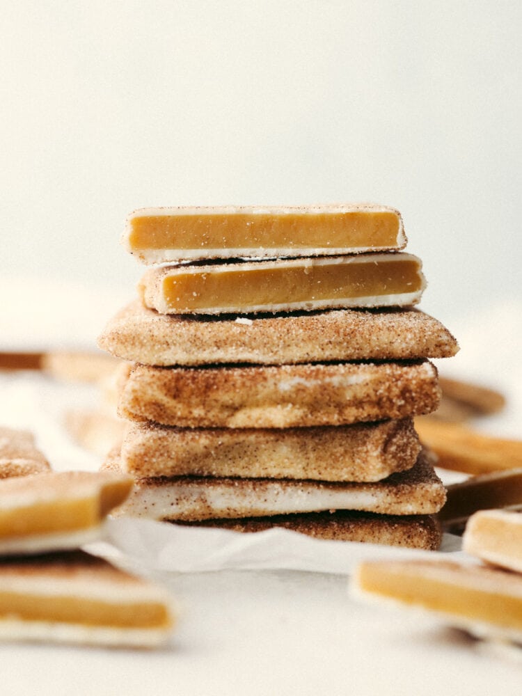 A stack of churro toffee. The top piece is broken in half so that you can see the inside. 