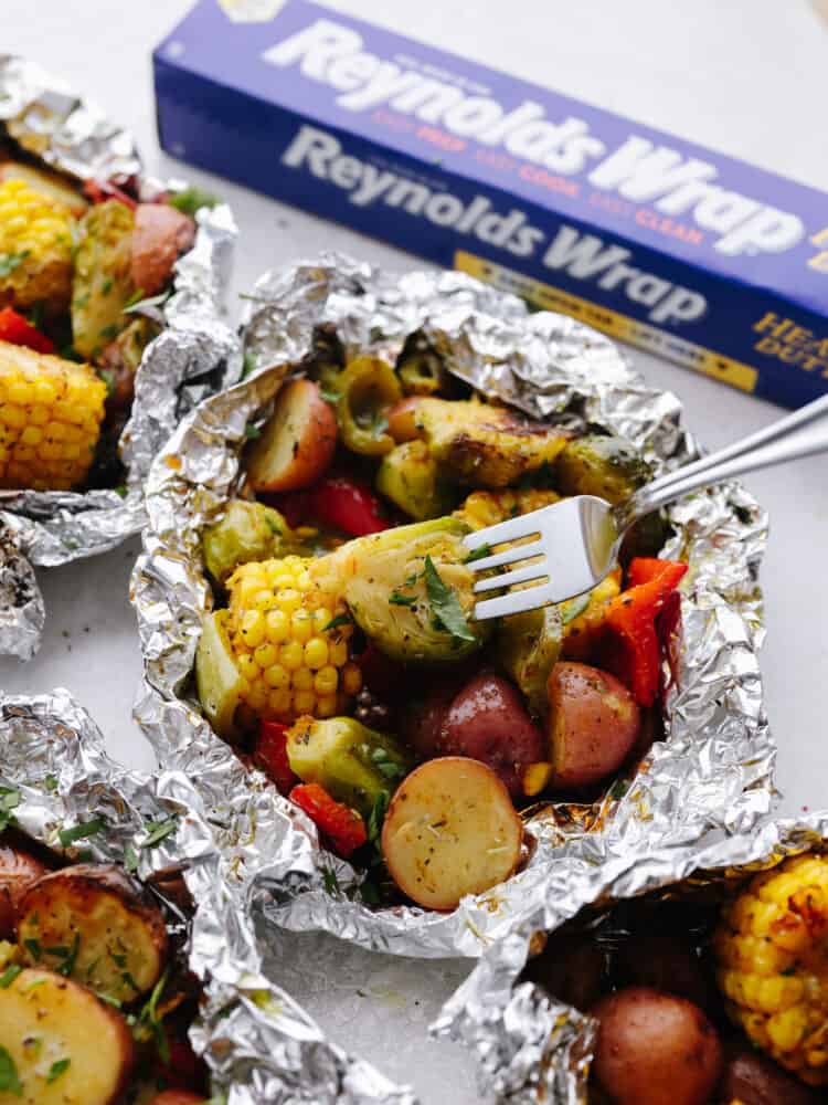 Vegetables in the foil pack with a fork. 