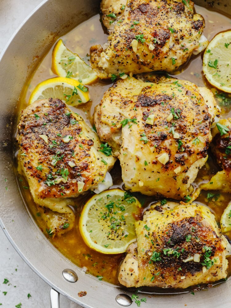 Closeup of brown butter lemon pepper chicken in a metal skillet.